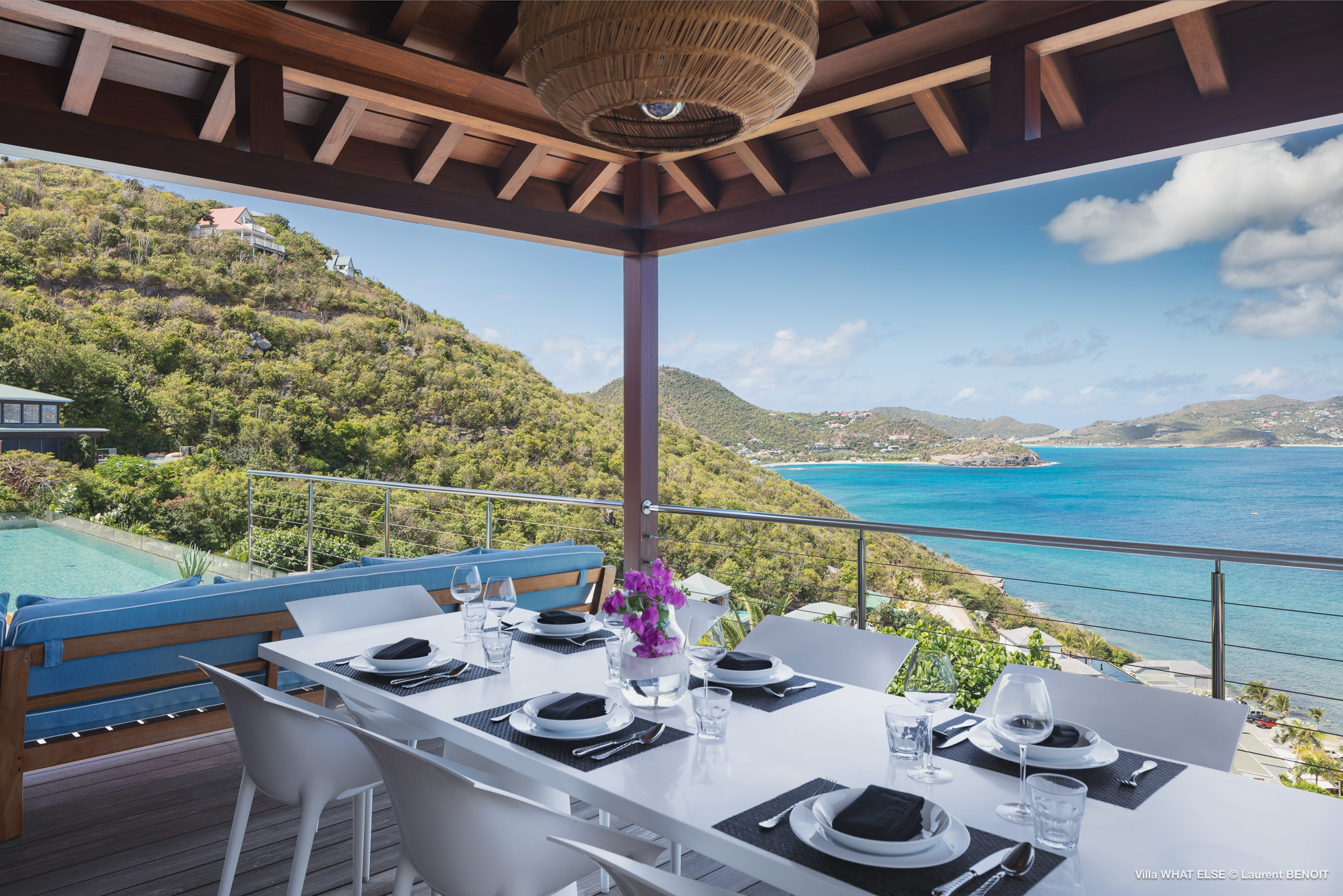 Covered dining terrace with sea view and modern table at luxury villa rental in St Barts