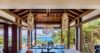 Open-air dining area in a St Barts villa with wooden ceiling, pendant lights and panoramic ocean views