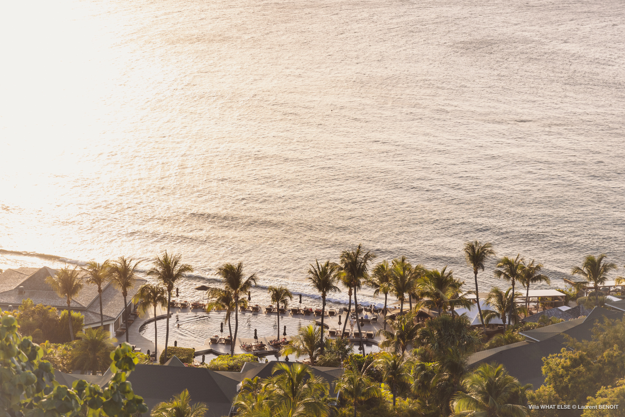 Sunset view of a palm-lined beach near a St Barts villa with golden light over the Caribbean Sea