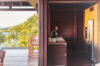 Modern kitchen in a St Barts villa opening to a wooden terrace with bar seating and tropical views