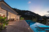 Twilight view of infinity pool and terrace with dining area at a luxury villa in St Barts