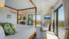Bright bedroom in St Barts villa with canopy bed, terrace access, and ocean views