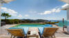 Infinity pool at St Barts villa with sun loungers facing Caribbean hills and ocean