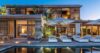 Twilight view of luxury St Barts villa with poolside loungers and softly lit suites.