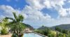 Infinity pool of a St Barts villa with panoramic hillside and ocean views surrounded by tropical greenery
