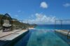 Infinity pool at St Barts villa with panoramic ocean views and modern deck seating.