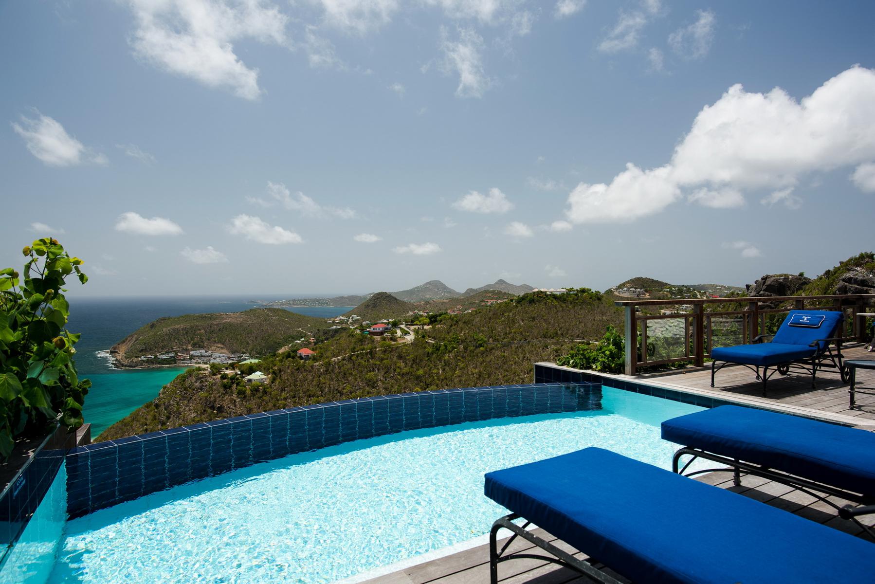 pool with blue loungers and panoramic hillside ocean view at St Barthelemy villa rental