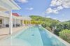 Infinity pool at luxury villas St Barts surrounded by lush tropical hillside