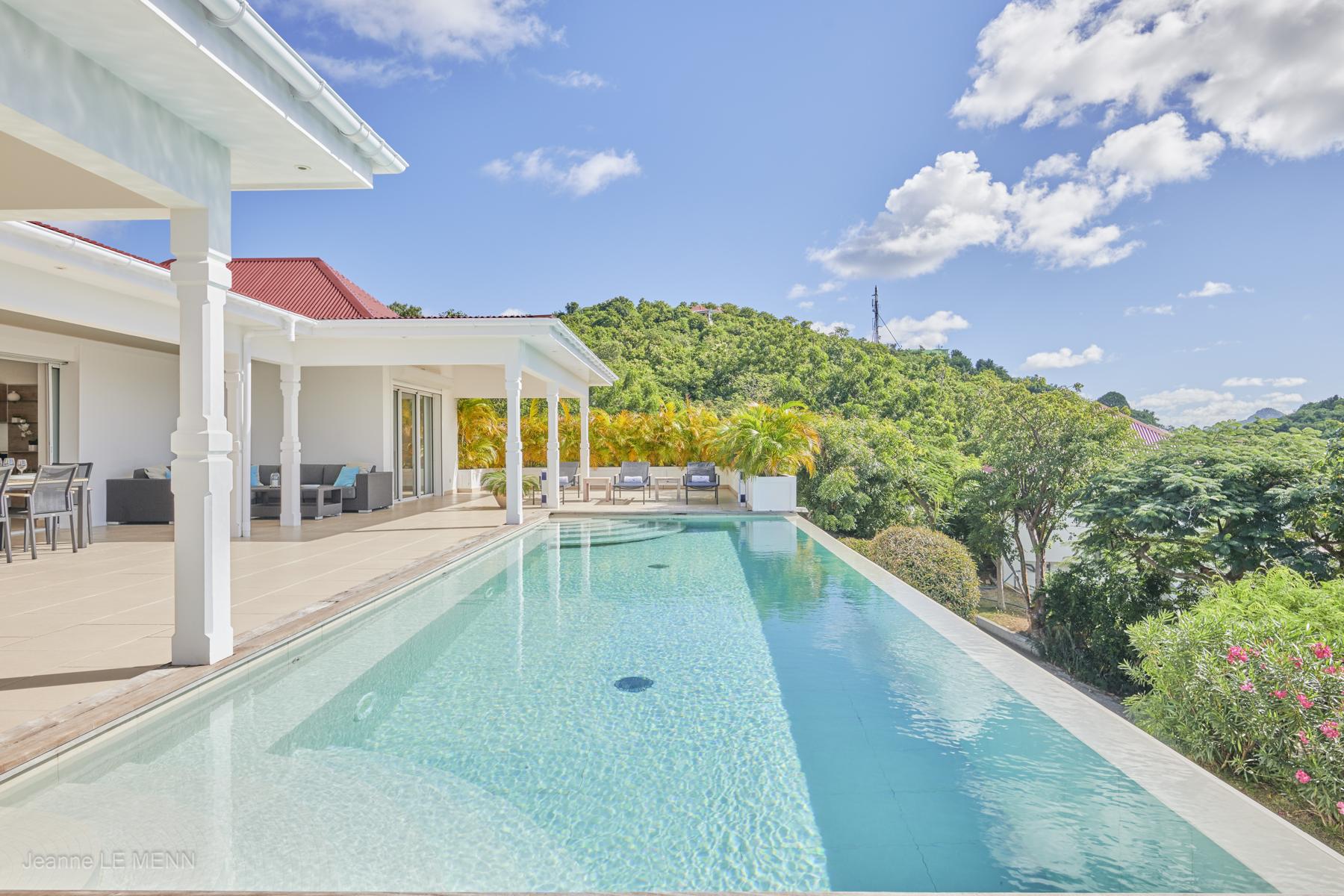 Infinity pool at luxury villas St Barts surrounded by lush tropical hillside