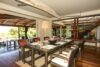 Indoor dining area in St Barts villa rental with rattan chairs and garden views