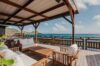 Covered ocean-view terrace with wooden lounge furniture at a luxury villa in St Barts.