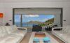 Living room with white sofas opening to balcony and ocean views in a St Barts villa rental