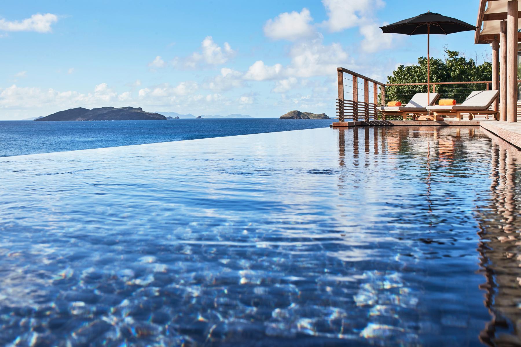Seafront infinity pool at St Barts villa with loungers and panoramic Caribbean views