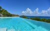 Infinity pool with panoramic ocean view and tropical hillside backdrop at luxury villa in St Barts
