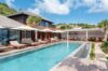 Luxury St Barts villa with long swimming pool, sun loungers, and shaded outdoor living spaces.