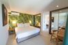 Bedroom with tropical wallpaper, king bed, and modern furnishings at private villa rental in St Barts