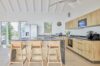 Spacious kitchen in St Barts villa hire with wooden cabinetry and breakfast bar
