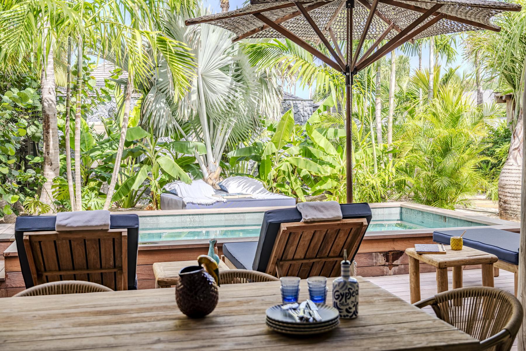 Shaded terrace with dining table, sun loungers, and plunge pool at private villa rental in St Barts