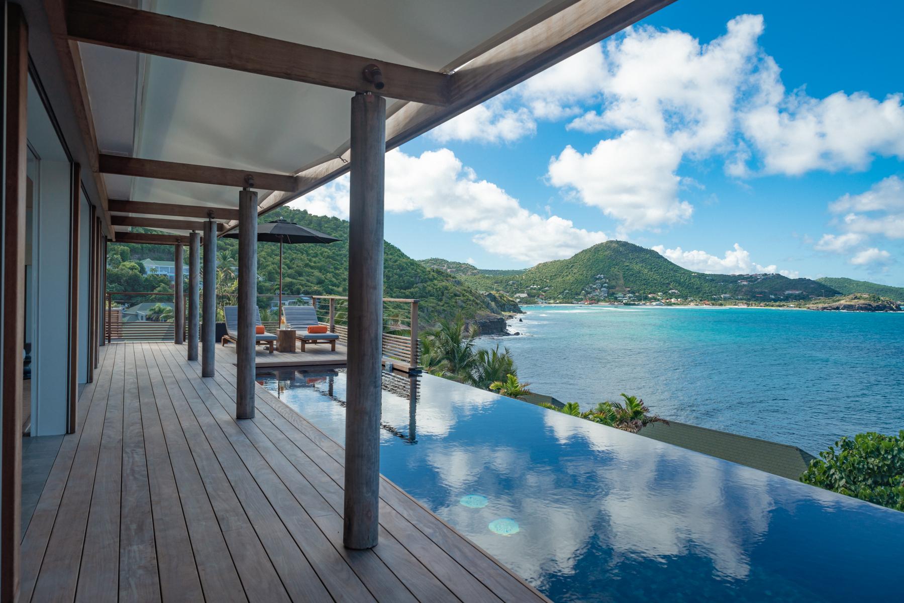 Contemporary St Barts villa with infinity pool and wooden terrace overlooking turquoise bay