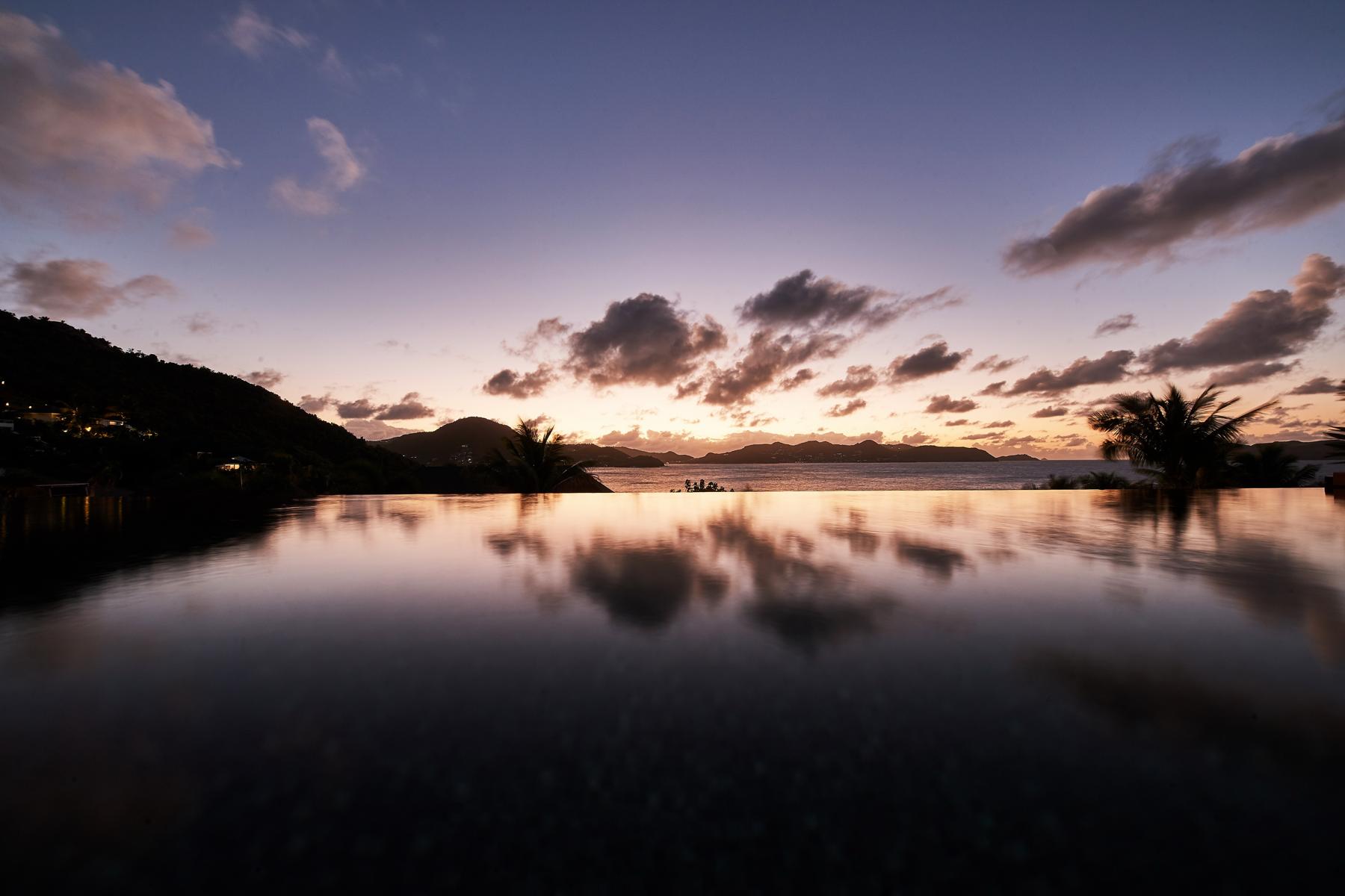 Infinity pool at St Barts villa reflecting sunset skies over Caribbean horizon