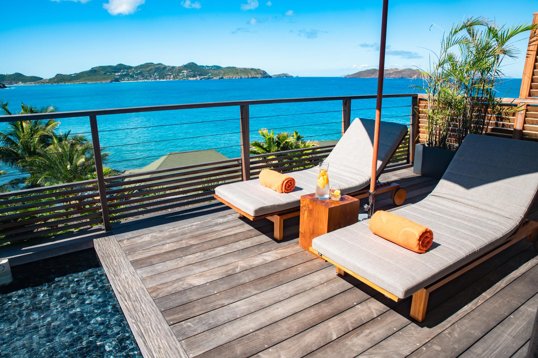 Private deck at St Barts villa with sun loungers overlooking turquoise Caribbean Sea