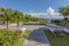 Garden pool at a St Barts villa with wooden deck, white sun loungers, and shaded pavilion surrounded by tropical greenery.