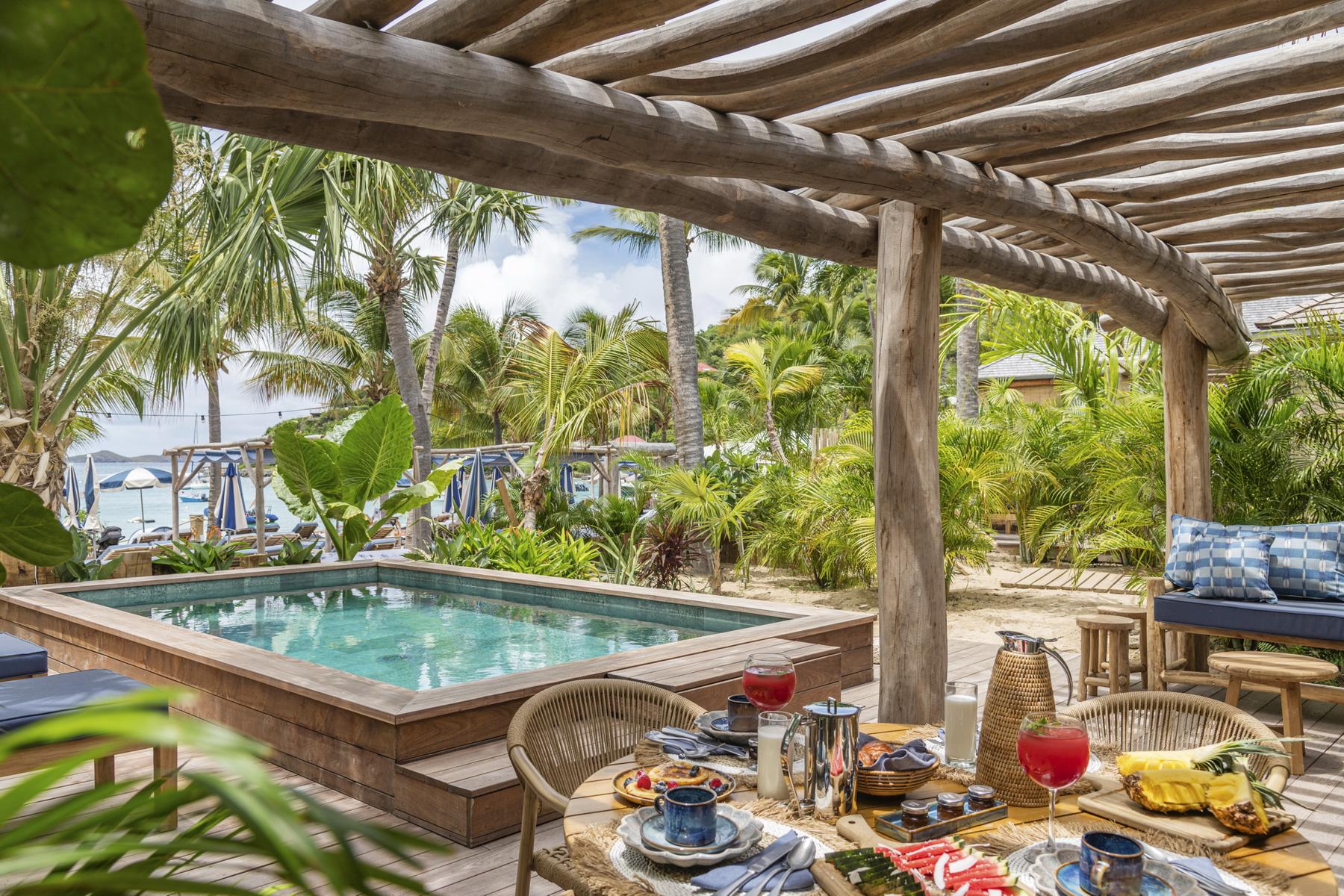 Private villa terrace in St Barts with plunge pool, tropical garden, and alfresco dining table.