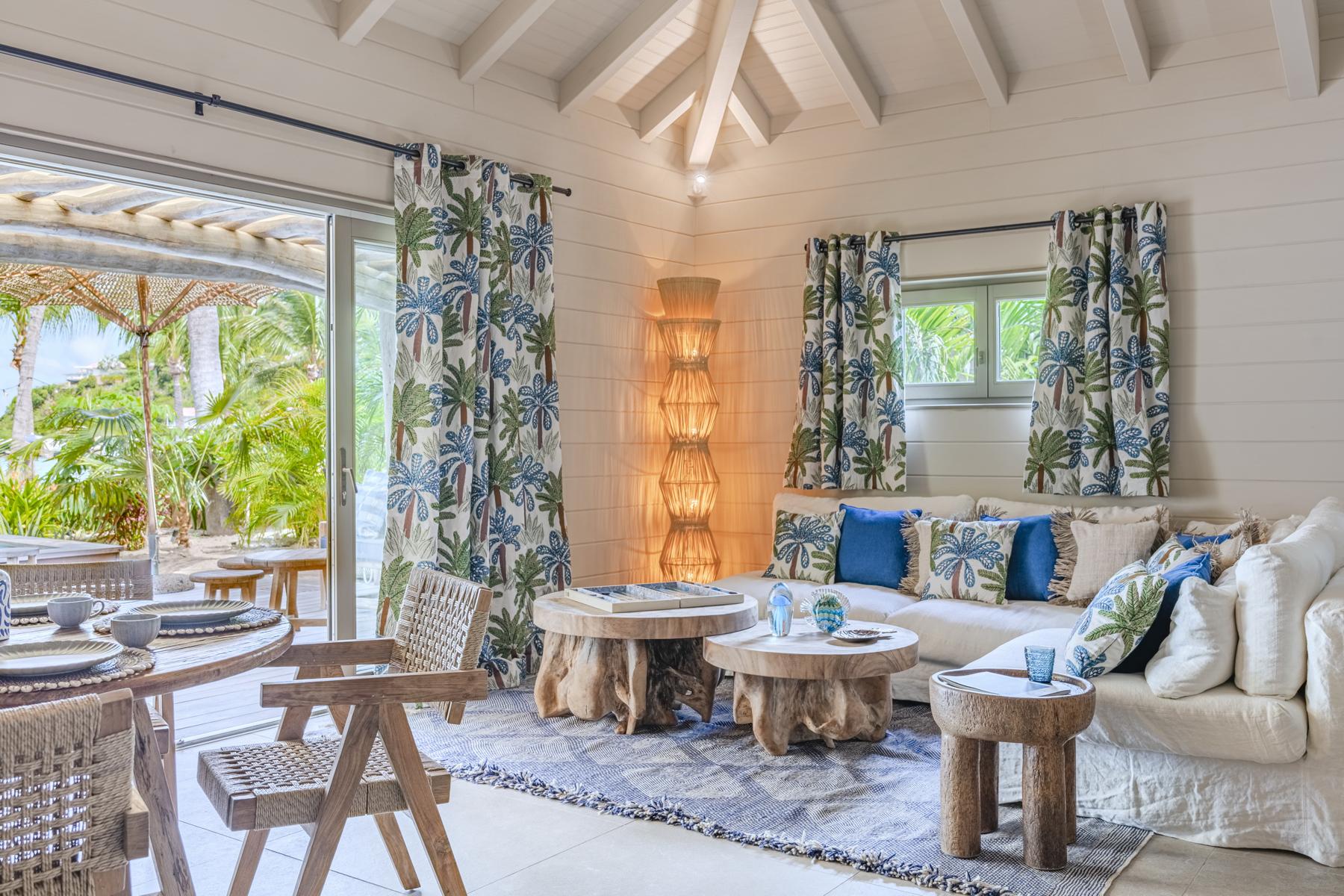 Bright villa living room in St Barts with tropical décor, garden view, and natural wood accents.