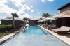 Long infinity pool lined with sun loungers and shaded terraces at a private villa in St Barts.