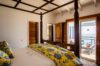 Bedroom with four-poster bed, ocean view terrace, and wooden accents at St Barts villa rental