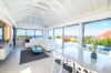 Bright open-plan living and dining area in a St Barts villa with sea views through panoramic windows