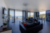 Spacious living room in a St Barts villa with floor-to-ceiling glass doors opening to a terrace and sweeping ocean views.