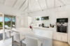 Bright kitchen in St Barts villa rentals with white island and terrace access