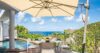 Shaded terrace dining area with pool and ocean view at a St Barts villa rental