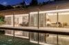 Elegant St Barts villa with poolside terrace illuminated by soft evening lights.