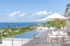 Expansive pool terrace at St Barts villa with sun loungers, umbrellas, and panoramic sea views