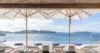 Seafront terrace at St Barts villa with sun loungers under white umbrellas overlooking the bay