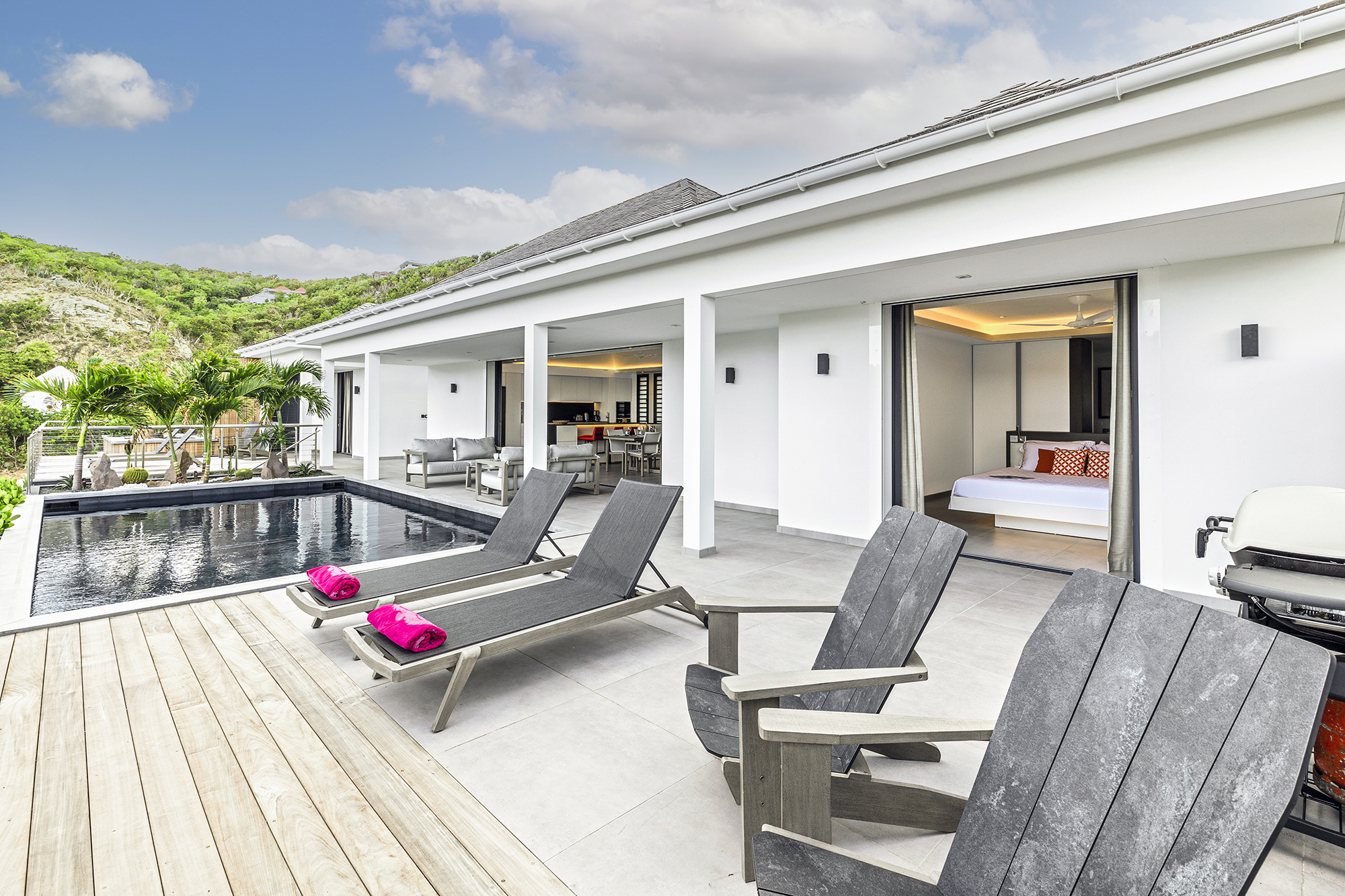 Elegant St Barts villa with poolside deck, sun loungers, and open bedrooms blending indoor comfort with outdoor Caribbean living.