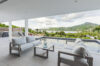 Covered terrace of a St Barts villa with cushioned lounge seating, infinity pool, and hillside views over the Caribbean Sea.