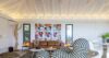Contemporary living room in St Barts villa with designer furniture, vaulted ceiling, and vibrant wall art.