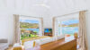 Luxury St Barts villa living area with contemporary décor, wide glass doors, and sweeping sea views.