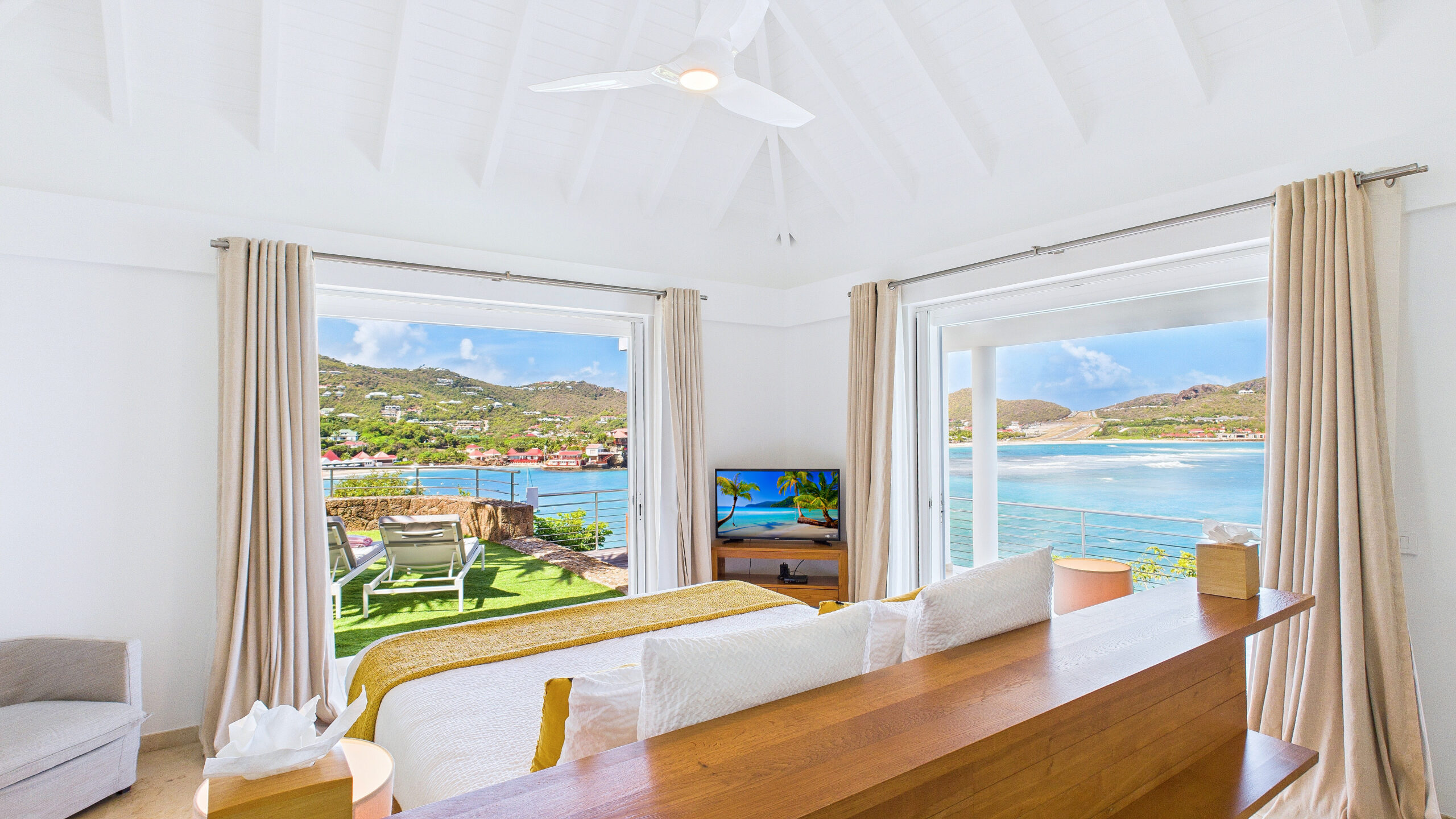 Luxury St Barts villa living area with contemporary décor, wide glass doors, and sweeping sea views.