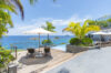 Sunlit pool area offering breathtaking panoramic views of the ocean and distant coastline