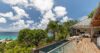 Terrace of hillside St Barts villa with infinity pool, ocean views, and tropical greenery.