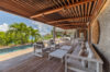 Shaded wooden terrace with lounge seating and poolside view at luxury villa in St Barts