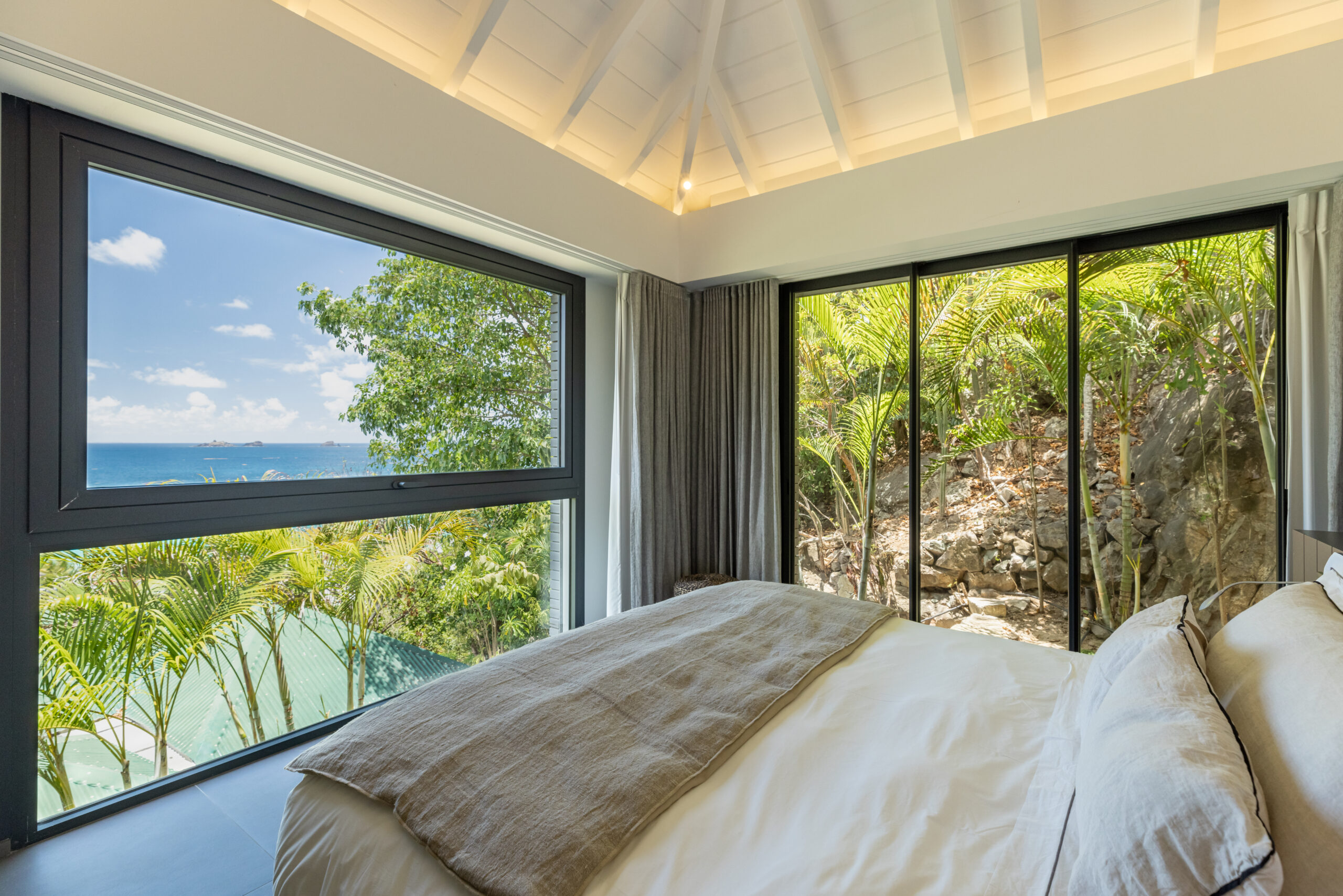 Bedroom with floor-to-ceiling windows and sea view in a luxury St Barts villa rental