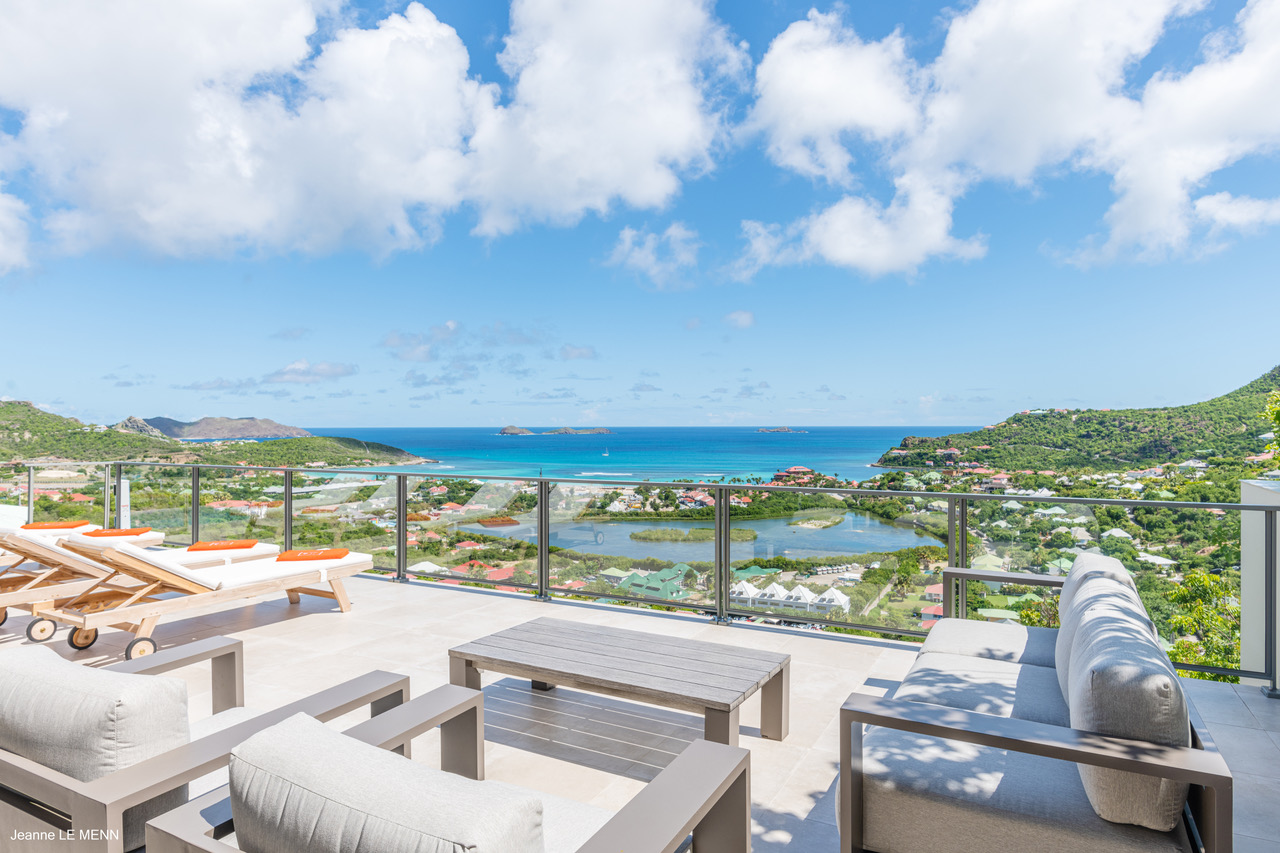 Terrace lounge with cushioned seating and panoramic Caribbean Sea views at a hillside luxury St Barts villa rental.