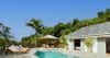 Serene pool terrace at a St Barts villa rental with shaded cabana and sun loungers.