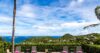 Sun loungers at a St Barts villa facing lush hills and sweeping ocean views under a bright Caribbean sky.