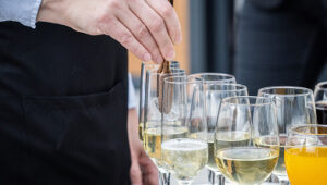 A server preparing a tray of champagne and cocktails at a luxury St. Barts villa event.